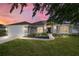 Charming home exterior with a lush lawn, well-maintained landscaping, and inviting entrance at dusk at 9595 Sw 51St Cir, Ocala, FL 34476
