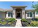 Close-up of an inviting home entrance with a decorative door, sidelights, and manicured landscaping at 9595 Sw 51St Cir, Ocala, FL 34476