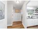 Inviting hallway featuring hardwood floors, wainscoting, and access to a well-lit bathroom at 9595 Sw 51St Cir, Ocala, FL 34476