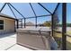 A screened-in patio features a gray hot tub with a gray lid and string lights. The patio floor is light-colored concrete at 9595 Sw 51St Cir, Ocala, FL 34476