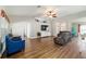 A stylish living room featuring wood floors, blue chairs, and a view of the dining area at 9595 Sw 51St Cir, Ocala, FL 34476