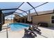 Inviting screened pool area with comfortable lounge chairs and umbrella, perfect for relaxation and outdoor enjoyment at 9595 Sw 51St Cir, Ocala, FL 34476