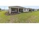 An expansive backyard with lush green grass, landscaping, and a view of the covered patio at 9871 Sw 105Th Ct, Ocala, FL 34481