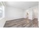 Bright bedroom featuring durable gray wood flooring, white walls, and ensuite bath and walk-in closet at 9871 Sw 105Th Ct, Ocala, FL 34481