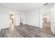 Spacious bedroom with modern gray wood floors, complemented by white walls, walk-in closet, and adjacent bathroom at 9871 Sw 105Th Ct, Ocala, FL 34481