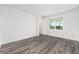 Inviting bedroom with stylish gray wood floors, bright window view, and neutral white walls at 9871 Sw 105Th Ct, Ocala, FL 34481