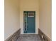 Stylish teal front door with sidelight and decorative hardware, framed by stone accents at 9871 Sw 105Th Ct, Ocala, FL 34481