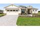 Charming single-Gathering home features a well-manicured lawn, stone accents, and a brick paver driveway at 9871 Sw 105Th Ct, Ocala, FL 34481