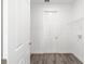 A bright, white laundry room with gray plank flooring, a wire rack, and a white door at 9871 Sw 105Th Ct, Ocala, FL 34481