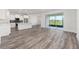 Open-concept living area with wood-look floors, large sliding doors, and ample natural light at 9871 Sw 105Th Ct, Ocala, FL 34481