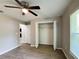 Neutral bedroom with ceiling fan, closet and wood-look floors at 9983 Sw 188Th Cir, Dunnellon, FL 34432