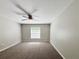 Bedroom showcasing neutral walls, carpeted floors, a ceiling fan, and a window at 9983 Sw 188Th Cir, Dunnellon, FL 34432
