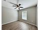 Bright, neutral bedroom featuring wood-look floors, ceiling fan and a large picture window at 9983 Sw 188Th Cir, Dunnellon, FL 34432