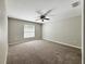 Large bedroom with a ceiling fan, window, neutral walls, and carpeted floors at 9983 Sw 188Th Cir, Dunnellon, FL 34432