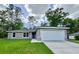 Charming single-story home featuring a two-car garage, well-manicured lawn, and beautiful landscaping at 9983 Sw 188Th Cir, Dunnellon, FL 34432