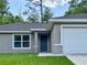 Close up of home featuring a front door, window with blinds, and attached garage at 9983 Sw 188Th Cir, Dunnellon, FL 34432