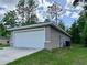 A two-car garage with a driveway and green grass at 9983 Sw 188Th Cir, Dunnellon, FL 34432