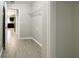 Hallway with tile floors leading to kitchen with stainless appliances and brown cabinets at 9983 Sw 188Th Cir, Dunnellon, FL 34432