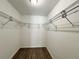 Walk-in closet with wood floors, a light, and metal storage racks at 9983 Sw 188Th Cir, Dunnellon, FL 34432