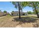 Home back exterior highlighting a spacious yard, mature trees, and fenced perimeter on a sunny day at 10081 Se 68Th Ct, Belleview, FL 34420