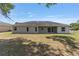 Rear view of a house featuring a well-maintained lawn, covered patio and fenced-in backyard at 10081 Se 68Th Ct, Belleview, FL 34420