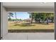 Expansive backyard view showing mature trees and a well-maintained lawn with an open patio area at 10081 Se 68Th Ct, Belleview, FL 34420