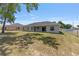 Backyard with manicured lawn, mature trees and fenced perimeter providing privacy and charm at 10081 Se 68Th Ct, Belleview, FL 34420
