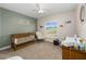 Cozy Bedroom with a wood crib, rocking chair, and natural light from window at 10081 Se 68Th Ct, Belleview, FL 34420