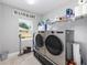 Bright laundry room featuring a front-load washer and dryer and plenty of storage space with a window view at 10081 Se 68Th Ct, Belleview, FL 34420