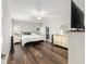 Bright main bedroom with hardwood floors, ensuite bathroom, and ceiling fan at 10081 Se 68Th Ct, Belleview, FL 34420