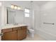 Well-lit bathroom features a vanity with wood cabinets, a large mirror, and a shower-tub combo at 10556 Sw 96Th Lane Rd, Ocala, FL 34481