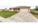 Beautiful single-story home featuring a well-manicured lawn, complemented by a paver driveway and two-car garage at 10556 Sw 96Th Lane Rd, Ocala, FL 34481