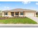 Charming single-story home featuring a manicured lawn, complemented by a paver driveway and welcoming two-car garage at 10556 Sw 96Th Lane Rd, Ocala, FL 34481