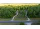 An aerial shot showcasing a gray home, a horseshoe driveway, and lush trees surrounding the property at 11806 Sw 61St Place Rd, Ocala, FL 34481