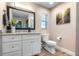 This half bathroom features a sleek vanity, stylish black framed mirror, and an efficient standard toilet at 11806 Sw 61St Place Rd, Ocala, FL 34481