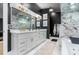 Well-lit bathroom with double vanity, framed mirror and black accent wall provides an abundance of space at 11806 Sw 61St Place Rd, Ocala, FL 34481