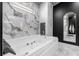 Bright bathroom with marble-style tiled accent walls, soaking tub and built-in storage at 11806 Sw 61St Place Rd, Ocala, FL 34481