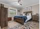 Charming bedroom features a ceiling fan, a window with blinds, wood furnishings, and decorative floral artwork at 11806 Sw 61St Place Rd, Ocala, FL 34481