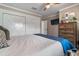 This bedroom boasts a modern white closet, TV and a mounted mirror complementing a comfy king-sized bed at 11806 Sw 61St Place Rd, Ocala, FL 34481