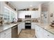 Updated kitchen with stainless steel appliances, granite countertops, and white cabinetry at 11806 Sw 61St Place Rd, Ocala, FL 34481