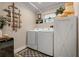 Well-organized laundry room with modern appliances, decorative wall art, and ample storage space at 11806 Sw 61St Place Rd, Ocala, FL 34481