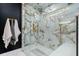 Luxurious glass enclosed shower with marble tile and gold fixtures create a spa-like experience at 11806 Sw 61St Place Rd, Ocala, FL 34481