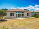 Rear exterior of home showcasing large windows and outdoor patio at 11945 Se 171St Loop, Summerfield, FL 34491