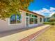 An outdoor patio with a view of the beautifully landscaped yard and bright natural lighting through large windows at 11945 Se 171St Loop, Summerfield, FL 34491
