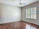 Bedroom with hardwood flooring, a ceiling fan, and a large window with blinds offering natural light at 11945 Se 171St Loop, Summerfield, FL 34491