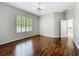 Spacious bedroom with wood floors, a ceiling fan, and a window with plantation shutters for natural light at 11945 Se 171St Loop, Summerfield, FL 34491