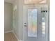 Home entryway featuring a glass door and sidelight next to a window with shutters and tile flooring at 11945 Se 171St Loop, Summerfield, FL 34491
