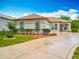 Charming home featuring a circle driveway with a decorative star inlay and well manicured landscaping at 11945 Se 171St Loop, Summerfield, FL 34491