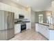 Open kitchen with stainless steel refrigerator, range, microwave, and ample cabinet space at 11945 Se 171St Loop, Summerfield, FL 34491