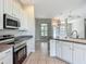 Modern kitchen with stainless steel appliances, white cabinets, an island with seating and an open floor plan at 11945 Se 171St Loop, Summerfield, FL 34491